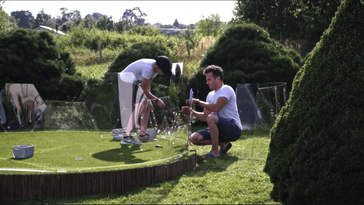 Two people assembling a GeoDomeX in a garden